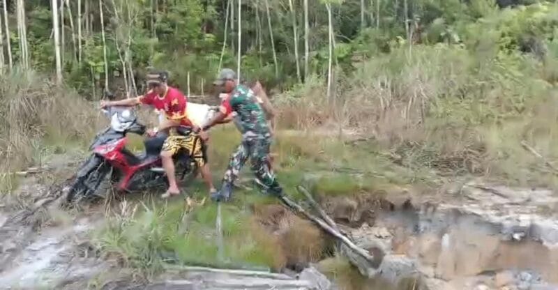 Warga Kesulitan Melintas, Babinsa Sebunga Bantu Lewati Jalan Yang Rusak