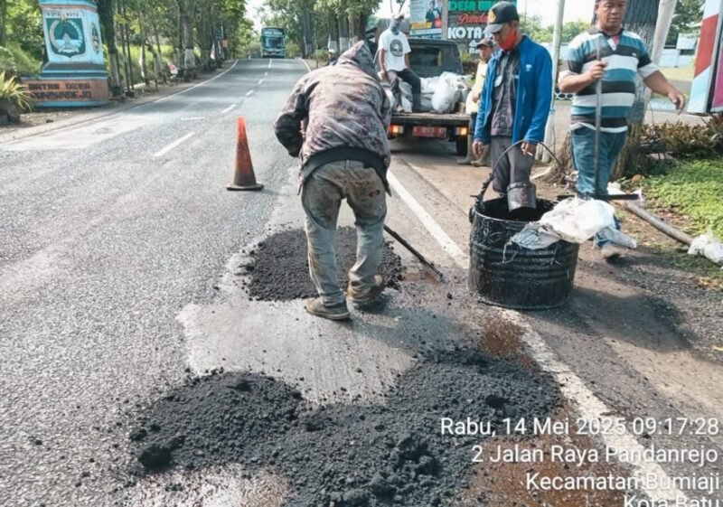 Foto: Petugas PUPR Kota Batu sedang melakukan penutupan jalan berlubang akibat hujan itensitas tinggi.