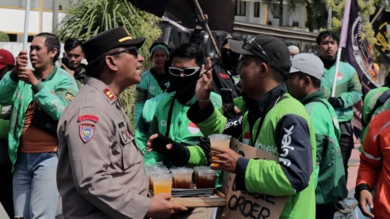 Humanis Polisi Kawal, Aksi Damai Driver Ojol di Jember Sambil Berbagi Minuman Dingin