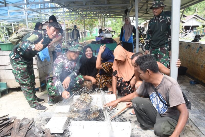 Kebersamaan Hangat di Lokasi TMMD Pengambau Hilir Luar: Ibu-ibu dan Satgas TNI Bakar Ikan untuk Makan Siang