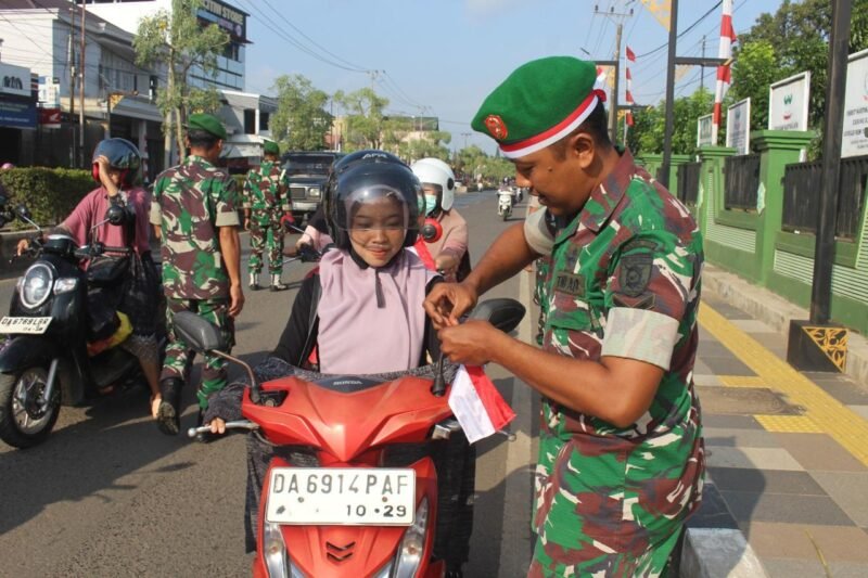 Sambut HUT RI Kodim 1009/Tla Bagi Dan Pasangkan Bendera Merah Putih Kepada Pengendara Yang Melintas Di Depan Makodim