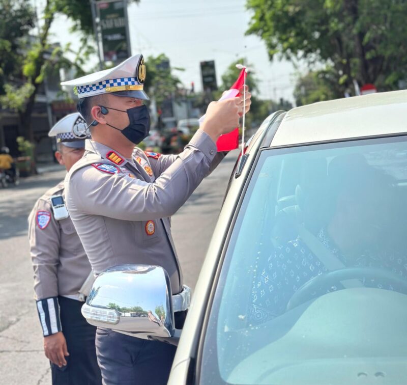 Semarak Jelang Hari Kemerdekaan RI ke -80, Polisi Berbagi Bendera Merah Putih di Nganjuk