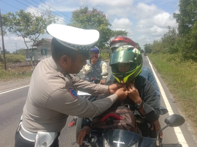 Anggota Polantas Bantu “Klik” Helm Pengendara Roda Dua Demi Keselamatan Saat Berkendara
