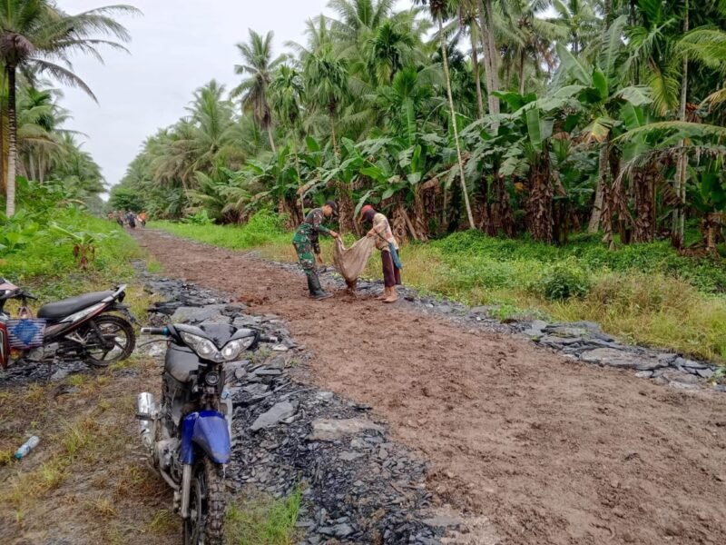 Sinergitas TNI Rakyat Anggota Koramil 04/Jawai Bersama Warga Gotong Royong Timbun Jalan