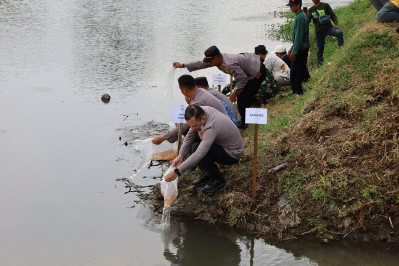 Foto: Kapolres Tulungagung AKBP Muhammad Taat Resdi memimpin kegiatan penaburan benih ikan tombro di bantaran Sungai Ngrowo atau Sungai Parit Agung di Desa Kendalbulur, Kecamatan Boyolangu, Kabupaten Tulungagung, Jumat (17/10/2025).