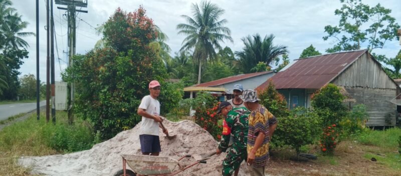 Babinsa Bantu Warga Angkut Pasir untuk Perbaiki Jalan Gang