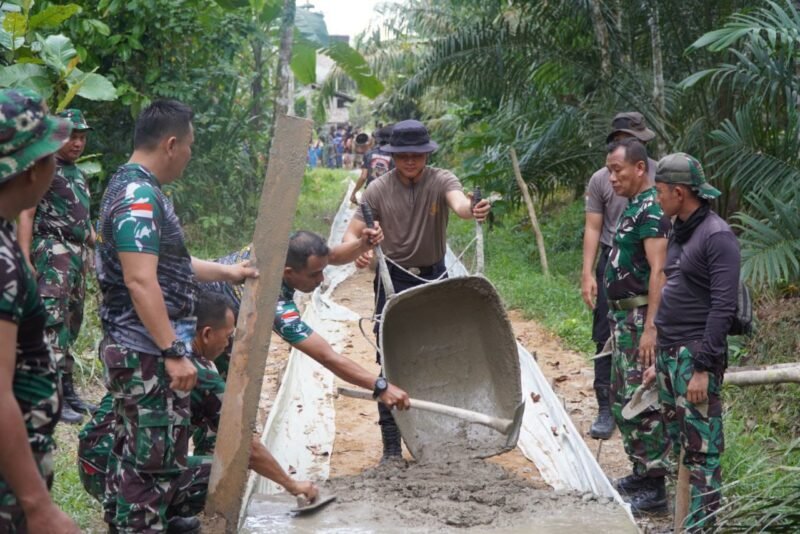 Anggota Polsek Turut Sukseskan Pembangunan Rabat Beton Program TMMD Regtas ke-126 Kodim 1208/Sambas