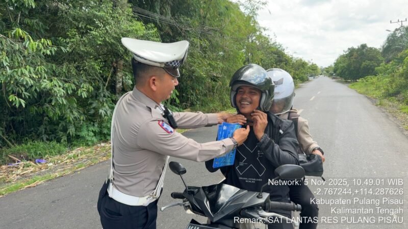 Personel Satlantas Polres Pulang Pisau Bantu “Klik” Helm Pengendara Roda Dua Demi Keselamatan Saat Berkendara