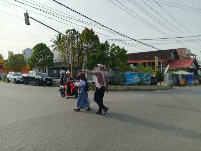 Satlantas Polres Pulang Pisau Bantu Anak Sekolah Menyeberang demi Wujudkan Keamanan Pagi Hari