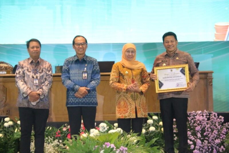 TargetNews.id/Foto/Selasa 25 nop 2025. Kabupaten Sidoarjo meraih piagam penghargaan sebagai TP2DD Kabupaten dengan Realisasi Kartu Kredit Indonesia Tertinggi Tahun 2025 dalam Kegiatan High Level Meeting (HLM) TIPD, TPDD dan TP2ED, Selasa 25/11/2025, oleh Gubernur Jawa Timur Khofifah Indar Parawansa. Penghargaan diterima langsung oleh Bupati Sidoarjo H.Subandi, SH.M.Kn.