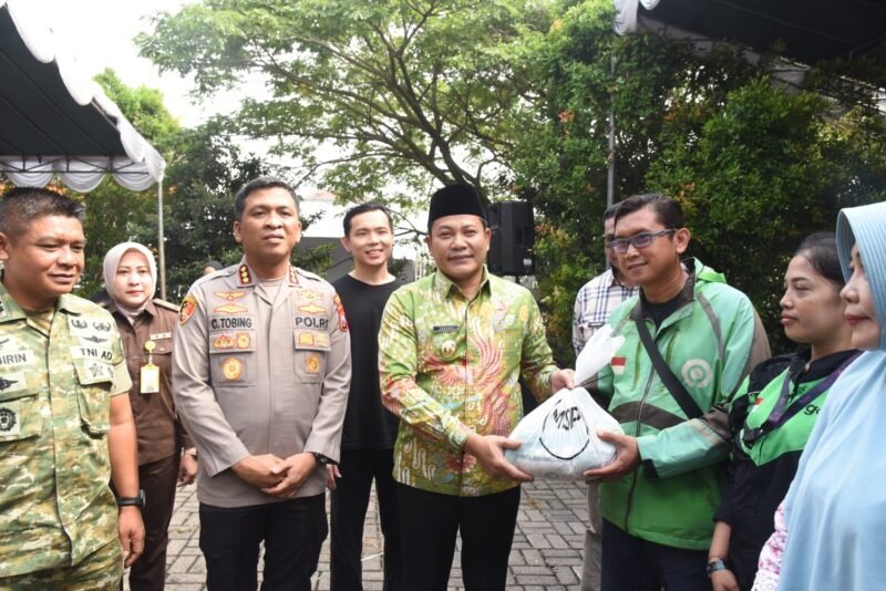 TargetNews.ID/Foto/1.000 paket Sembako dibagikan dalam Bakti Sosial/Baksos yang digelar Yayasan Mawar Sharon Peduli (MSP) bersama Forkopimda Sidoarjo, Kamis, (11/12). Selain Sembako, 1.000 porsi makan gratis juga disediakan dalam Baksos yang digelar di Perumahan Argent Park Kelurahan Sidoklumpuk Sidoarjo tersebut. Selain masyarakat sekitar, pengemudi Ojek Online/Ojol juga ikut menerima Sembako itu