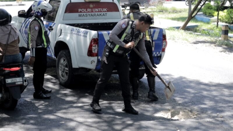 Foto: Polantas Polres Gresik Tambal Jalan Berlubang Demi Keselamatan Pengendara