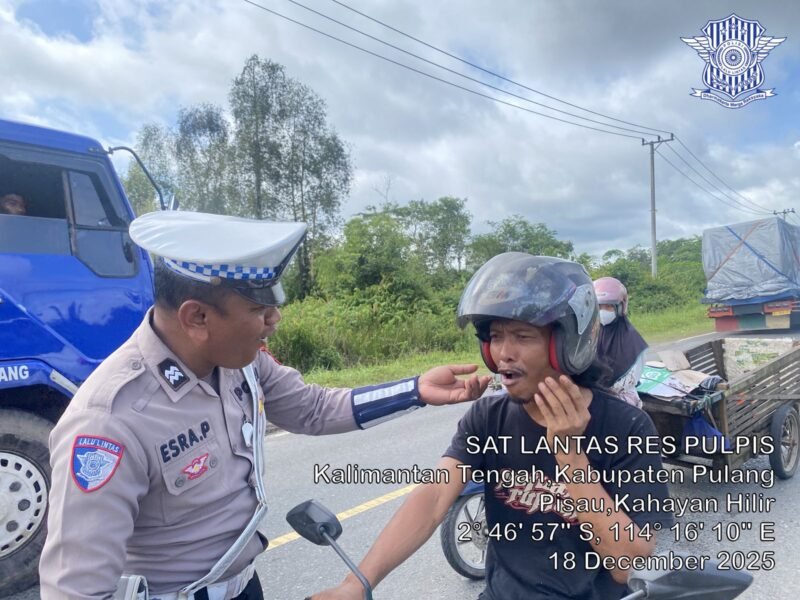 Foto: Satuan Lalu Lintas – Dengan Senyuman yang ramah Personel Satlantas Polres Pulang Pisau mengingatkan pengendara roda dua agar selalu klik helm saat berkendara. Kamis (18/12/2025).