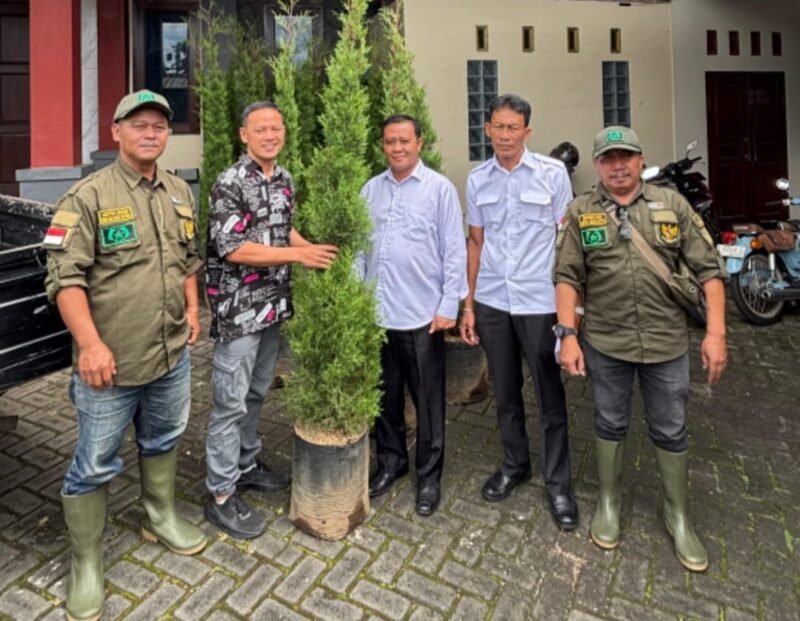 Foto ist : Tengah Sekdes Oro Oro Ombo Supriono, Kasun Krajan Hari, kanan Manajer PT.Winner Tech Lintas Nusa, serahkan pohon bibit Cemara pecut sejumlah 30 sebagai pohon pengganti.