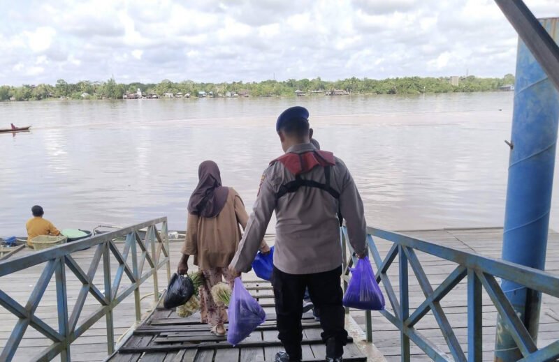 Satpolairud Polres Pulang Pisau Bantu Warga Pesisir Angkut Barang Belanjaan di Dermaga