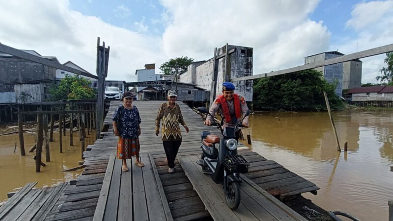 Satpolairud Polres Pulpis Bantu Lansia Seberangkan Motor di Dermaga Ferry