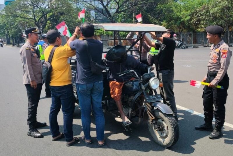 Sambut HUT ke-81 RI, Polres Pelabuhan Tanjung Perak Bagikan Bendera Merah Putih kepada Pengendara
