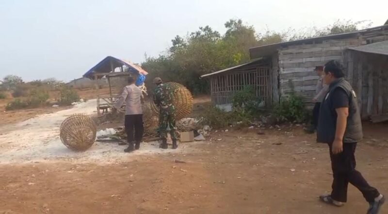 Keterangan Foto:
Petugas Polsek Sidayu bersama anggota Koramil Sidayu menertibkan bangunan semi permanen yang diduga pernah digunakan sebagai lokasi judi sabung ayam di perbatasan Desa Kertosono dan Desa Lasem, Kecamatan Sidayu, Gresik, Selasa (8/9/2026).