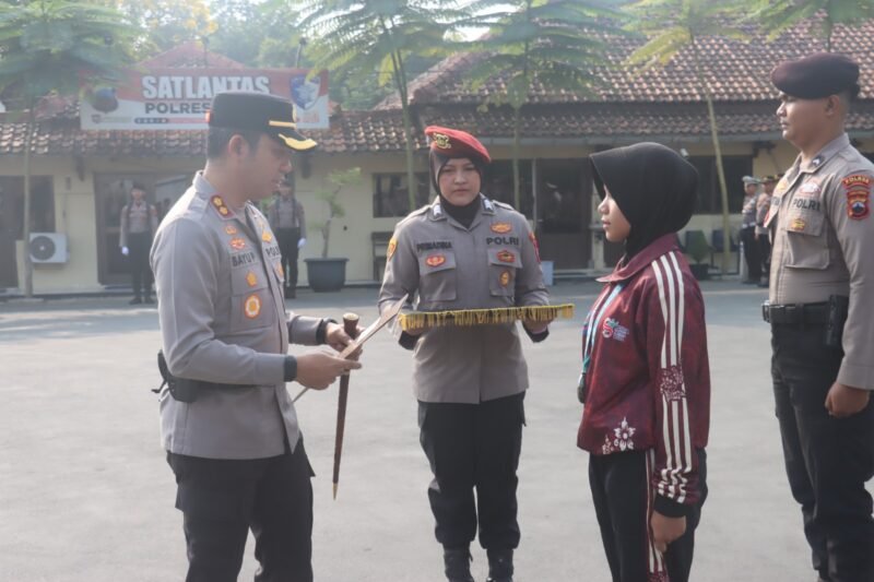 Keterangan foto:
Kapolres Tegal AKBP Bayu Prasatyo menyerahkan penghargaan kepada Rania Khanzaa Arfiana, pelajar SMP Negeri 1 Slawi peraih medali perak cabang yudo pada Pekan Olahraga Pelajar se-Jawa Tengah, saat upacara HAORNAS 2026 di halaman Polres Tegal.