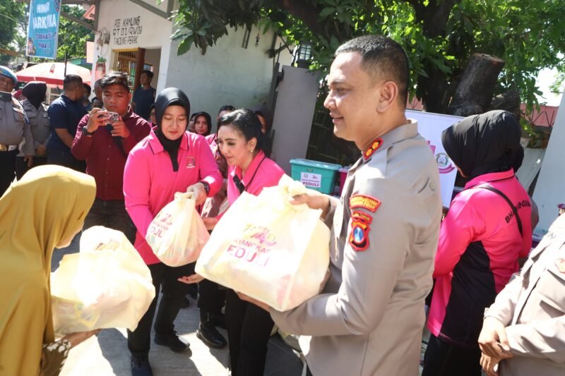 foto: Ketua Bhayangkari Cabang Pelabuhan Tanjung Perak Ny. Tiwi Irwan bersama Kapolres Pelabuhan Tanjung Perak AKBP Irwan Kurniawan AZ saat menyalurkan bantuan sosial kepada warga Kalimas Baru dalam rangka HKGB ke-74.