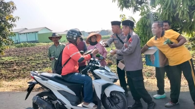 Kapolsek Adiwerna AKP S. Ibnu Akbar bersama personel membagikan 250 bungkus ponggol gratis kepada masyarakat dalam kegiatan Jumat Berkah di wilayah Adiwerna, Kabupaten Tegal.